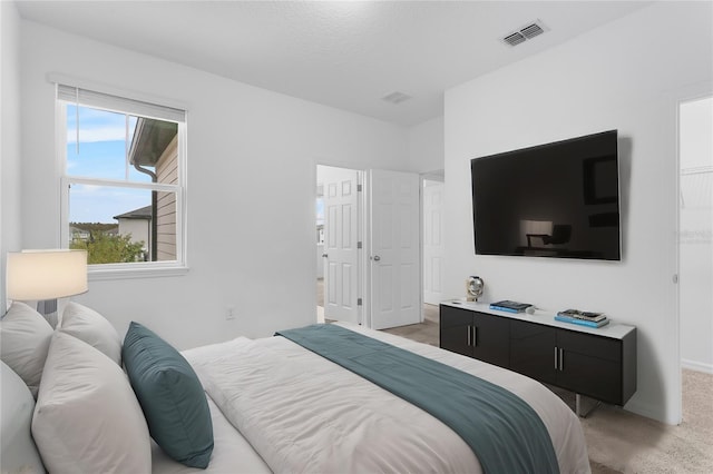 bedroom with a textured ceiling and light colored carpet