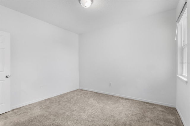 unfurnished room with light carpet