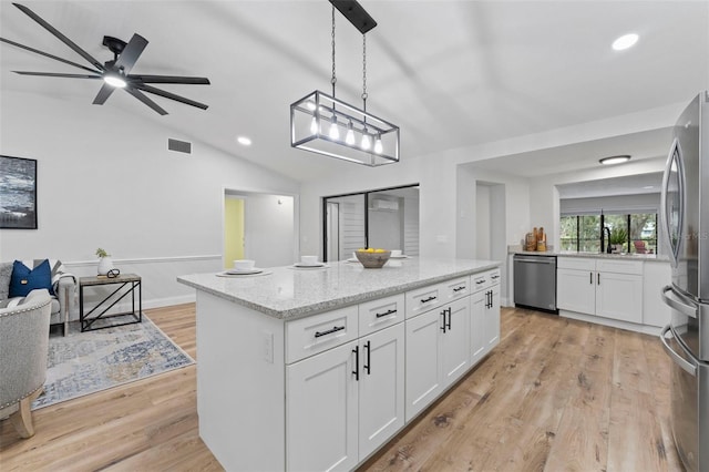 kitchen with pendant lighting, stainless steel appliances, white cabinetry, and light hardwood / wood-style floors