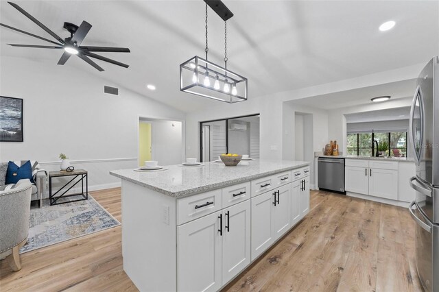 5016 Dorman Rd, Lakeland, FL 33813 - kitchen with appliances with stainless steel finishes, a center island, lofted ceiling, white cabinets, and light wood finished floors