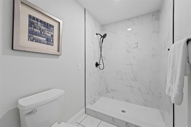 bathroom featuring a tile shower and toilet