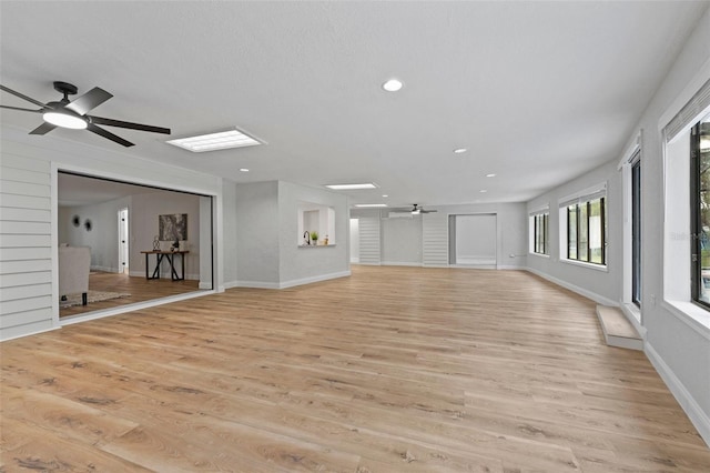 unfurnished living room featuring ceiling fan and light hardwood / wood-style flooring