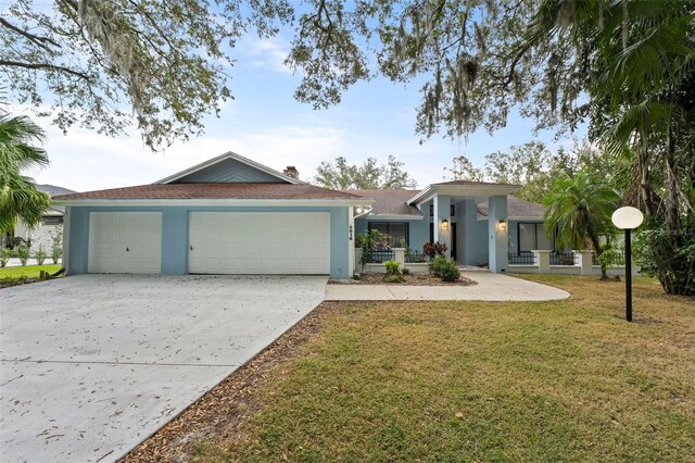 5016 Dorman Rd, Lakeland, FL 33813 - view of front of house featuring stucco siding, a garage, driveway, a front yard, and a chimney