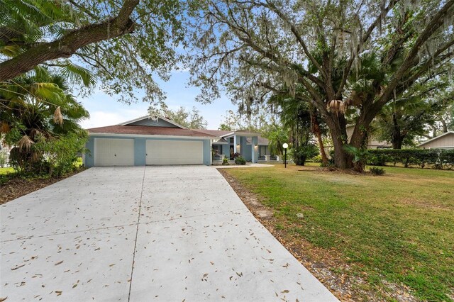 5016 Dorman Rd, Lakeland, FL 33813 - view of front of property with concrete driveway, a garage, and a front yard