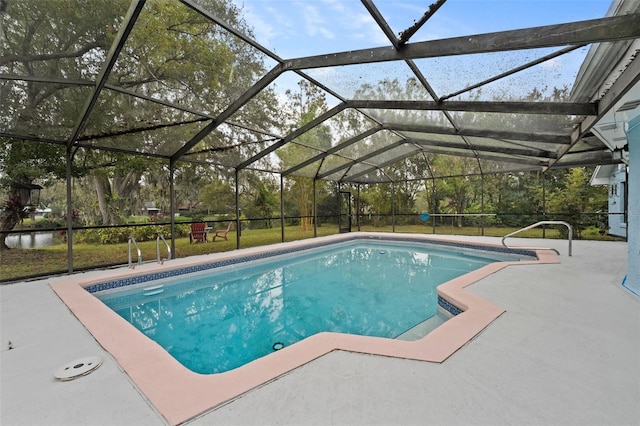 view of pool with glass enclosure and a patio