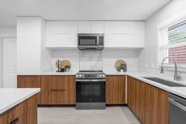 kitchen with sink, white cabinets, and appliances with stainless steel finishes