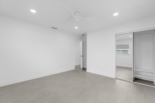 unfurnished bedroom featuring ceiling fan, light hardwood / wood-style floors, and a closet