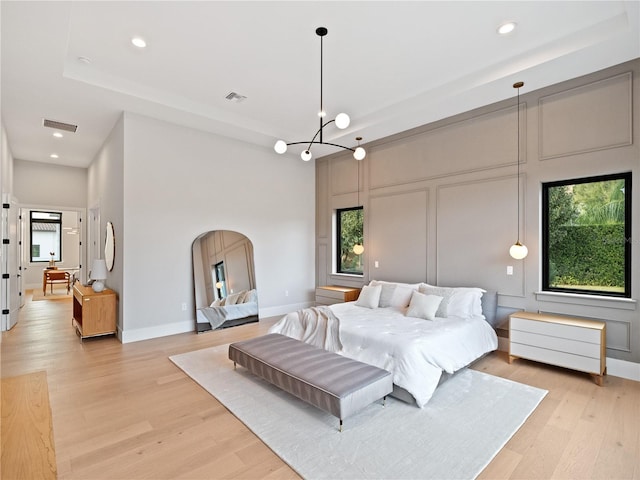 bedroom featuring a chandelier and light hardwood / wood-style flooring