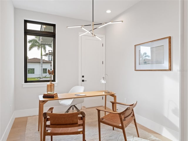 office featuring plenty of natural light, an inviting chandelier, and light wood-type flooring