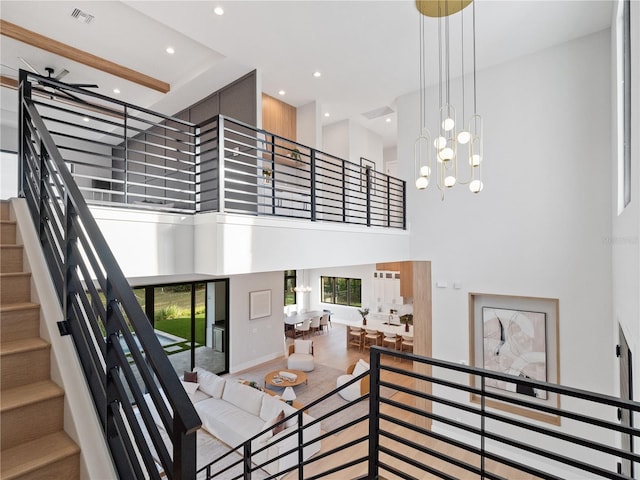 stairs featuring a towering ceiling and a notable chandelier