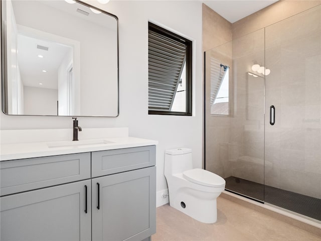 bathroom featuring toilet, vanity, and a shower with shower door