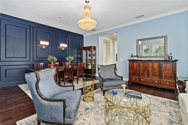 living room with crown molding, a chandelier, and dark hardwood / wood-style floors