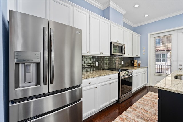 kitchen with light stone countertops, appliances with stainless steel finishes, dark hardwood / wood-style floors, and white cabinetry