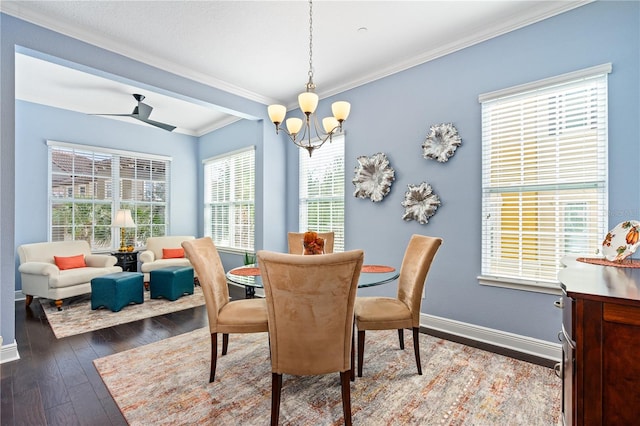 dining space featuring dark hardwood / wood-style floors, ornamental molding, and ceiling fan with notable chandelier