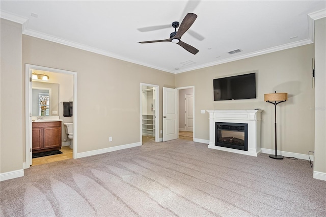 unfurnished living room with ceiling fan, crown molding, and light carpet