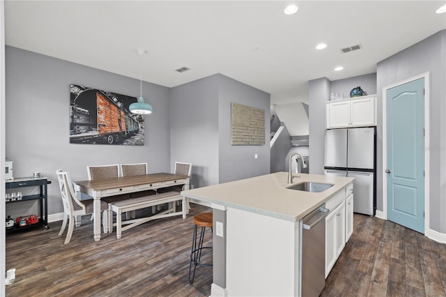 kitchen featuring visible vents, white cabinets, dark wood-style floors, appliances with stainless steel finishes, and a sink