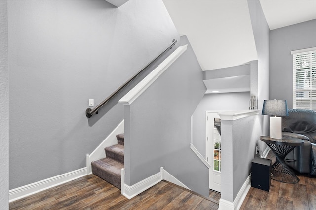 stairway with wood finished floors and baseboards