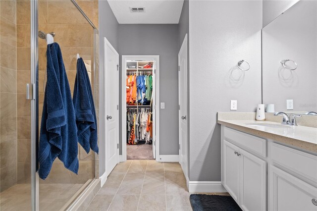 bathroom with a shower stall, visible vents, a walk in closet, and vanity