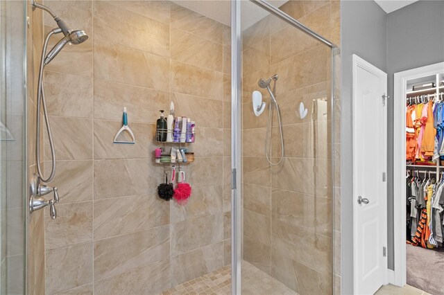 bathroom featuring a stall shower and a walk in closet