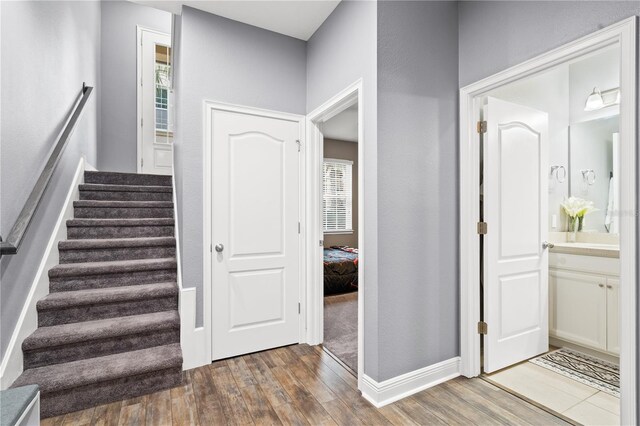 staircase featuring baseboards and wood finished floors