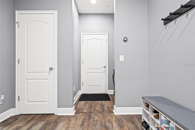 mudroom with dark wood-style floors and baseboards