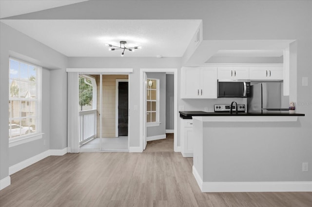 kitchen featuring sink, stainless steel appliances, white cabinetry, and light hardwood / wood-style flooring