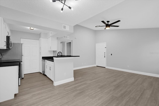 kitchen featuring appliances with stainless steel finishes, light hardwood / wood-style floors, and white cabinetry