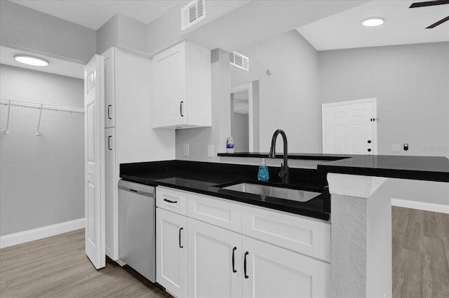 kitchen with kitchen peninsula, light wood-type flooring, sink, dishwasher, and white cabinetry