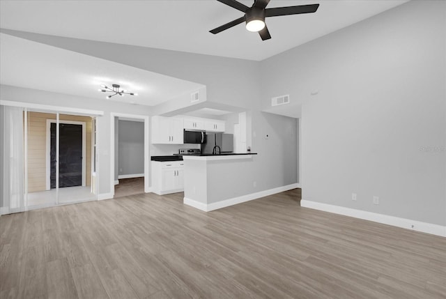 unfurnished living room featuring ceiling fan, light hardwood / wood-style floors, and vaulted ceiling