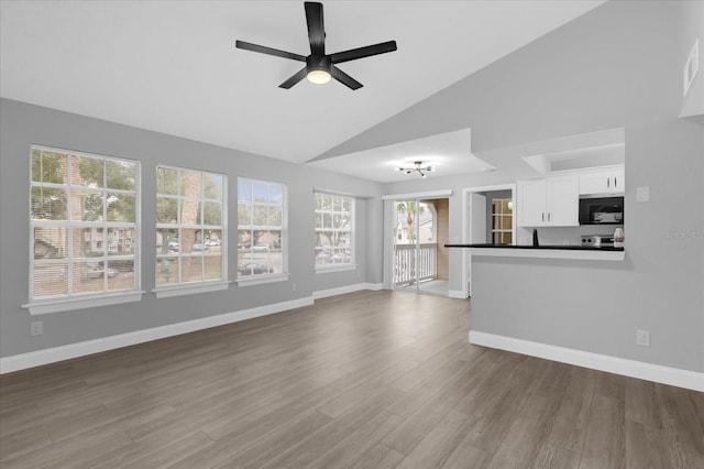 unfurnished living room with ceiling fan, high vaulted ceiling, and hardwood / wood-style flooring