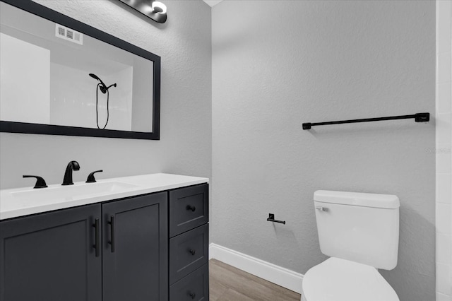 bathroom with wood-type flooring, vanity, and toilet