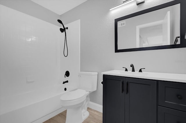 full bathroom featuring hardwood / wood-style floors, vanity, toilet, and bathtub / shower combination