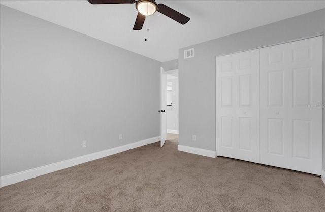 unfurnished bedroom featuring carpet, a closet, and ceiling fan