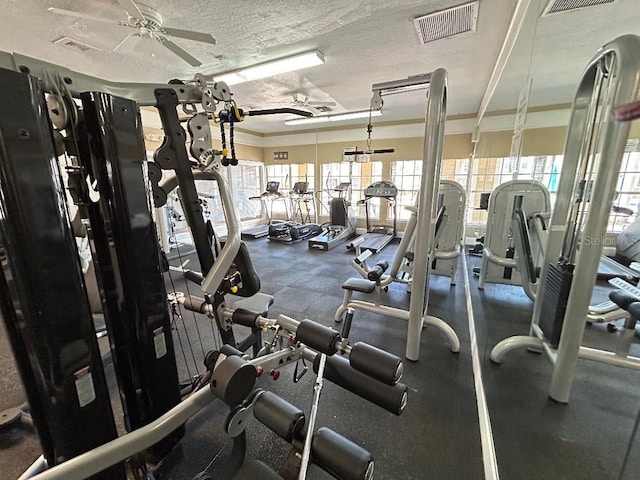 gym with ceiling fan, a textured ceiling, and ornamental molding