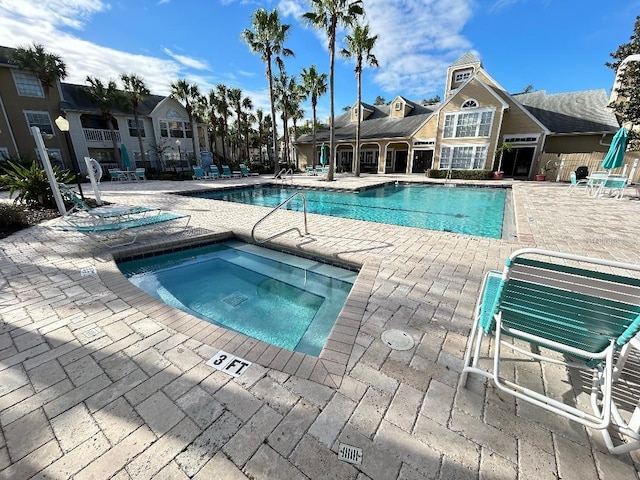 view of swimming pool featuring a patio area and a hot tub