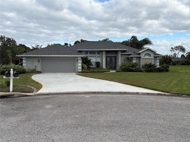 view of front of house with a front lawn, a garage, and french doors