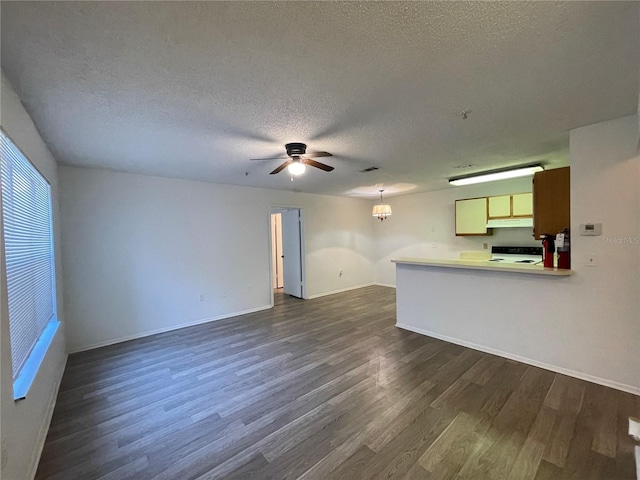 unfurnished living room featuring ceiling fan, dark hardwood / wood-style flooring, and a textured ceiling