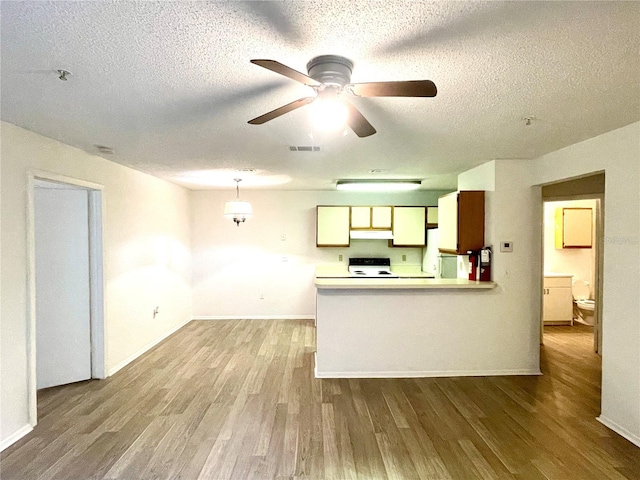 kitchen with ceiling fan, pendant lighting, light hardwood / wood-style floors, a textured ceiling, and white appliances