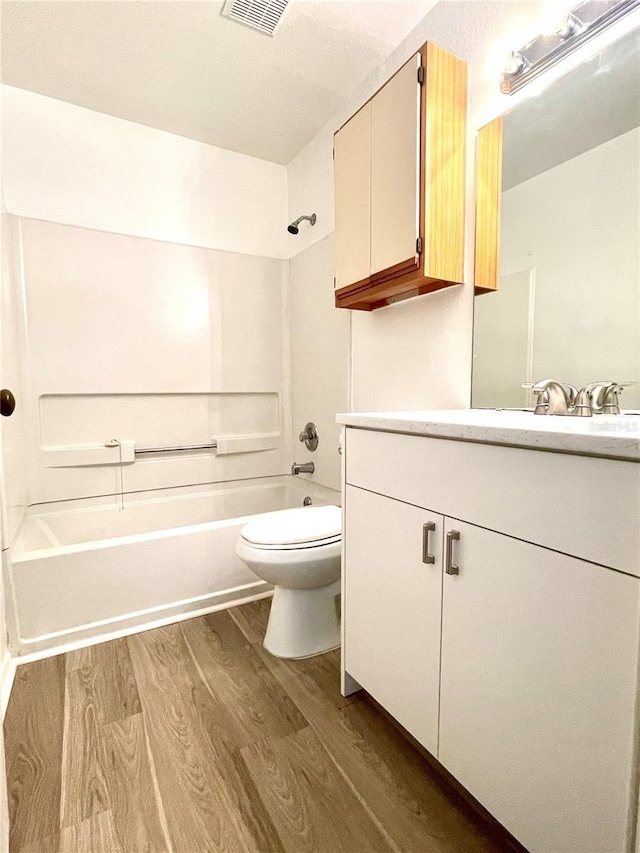 full bathroom with wood-type flooring, vanity, shower / bath combination, and toilet