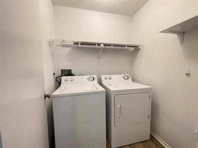 washroom featuring a textured ceiling, hardwood / wood-style flooring, and washing machine and dryer