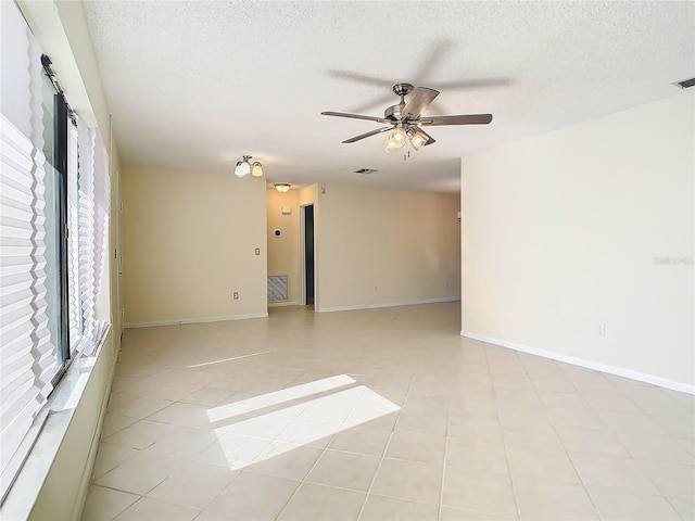 unfurnished room with ceiling fan, a healthy amount of sunlight, and a textured ceiling