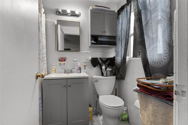 bathroom featuring vanity, toilet, and tile walls