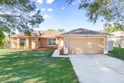 single story home featuring a front lawn and a garage