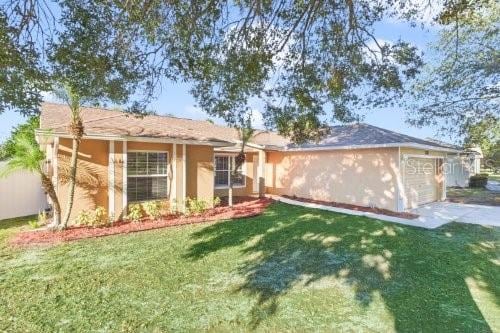 back of property featuring a yard and a garage