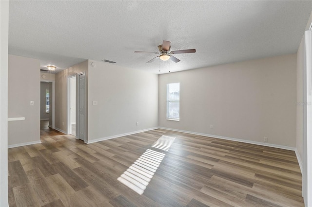 unfurnished room with ceiling fan, a textured ceiling, and hardwood / wood-style flooring