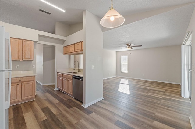 kitchen featuring sink, dark hardwood / wood-style flooring, stainless steel dishwasher, pendant lighting, and a textured ceiling