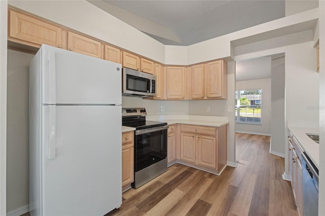 kitchen with light brown cabinets, dark wood-type flooring, and appliances with stainless steel finishes