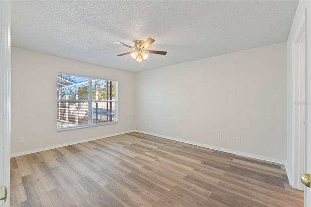 spare room with ceiling fan, light wood-type flooring, and a textured ceiling