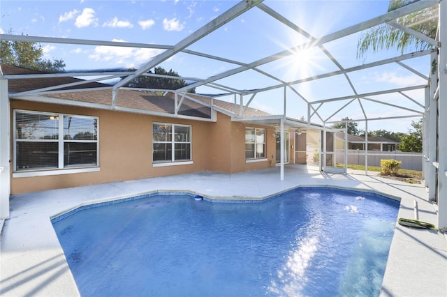 view of swimming pool featuring glass enclosure and a patio area