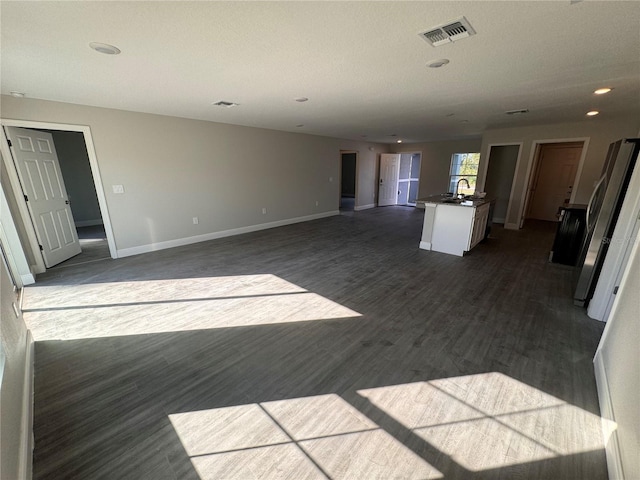 unfurnished living room featuring dark hardwood / wood-style flooring and sink